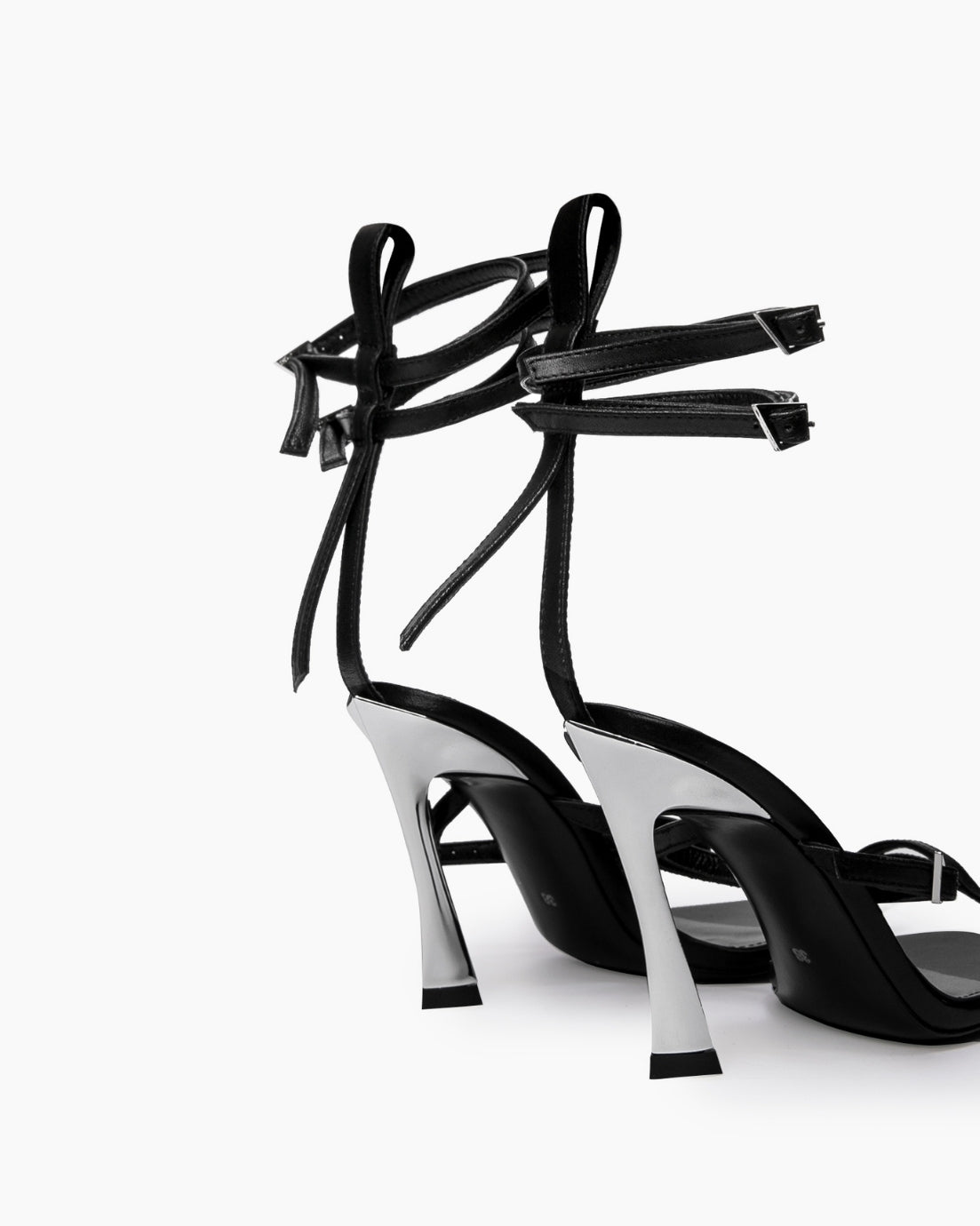 Rear view of black leather wrap heels showing sculptural flared heels and ankle straps