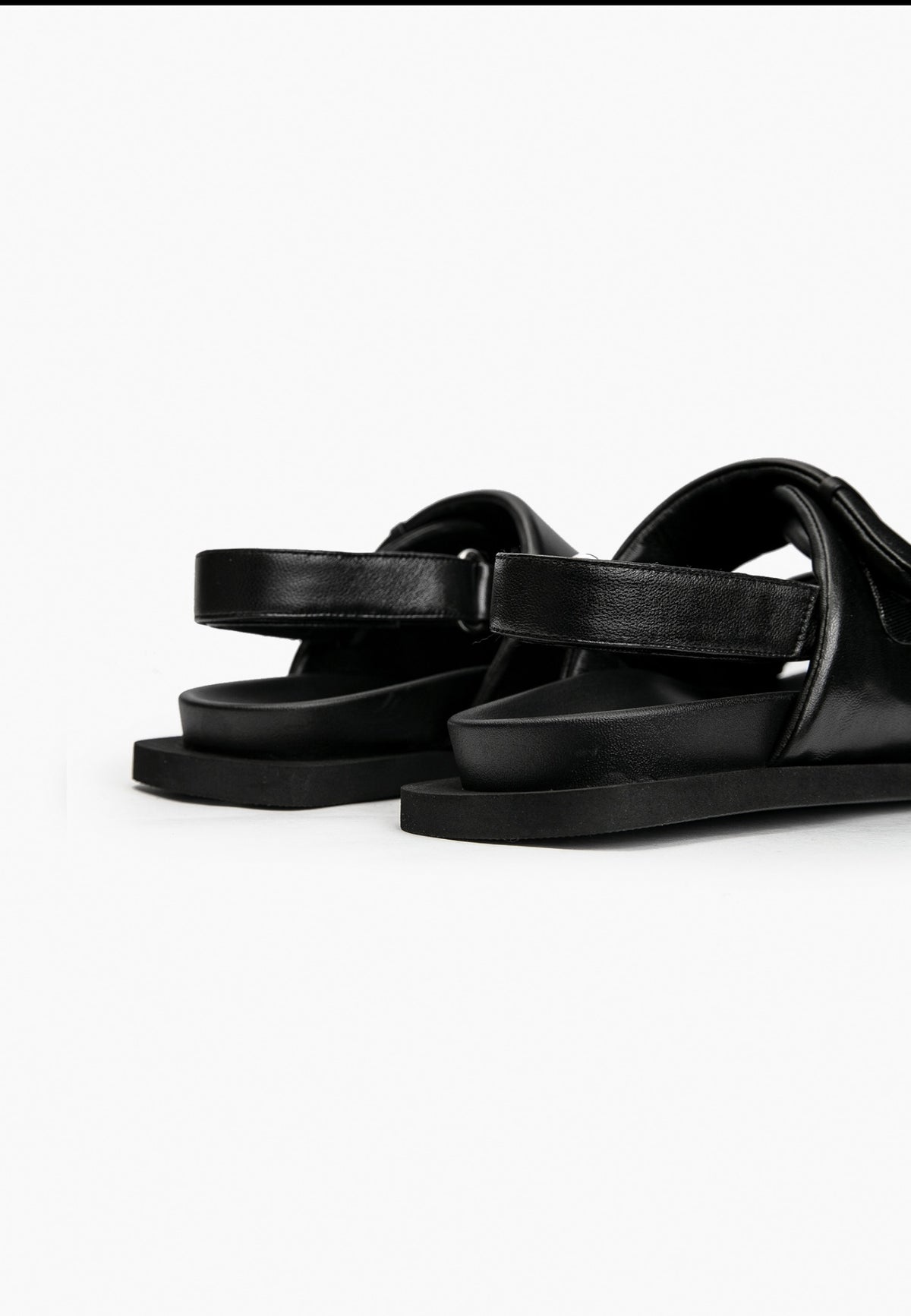 Rear detail of black leather comfort sandals with adjustable heel strap