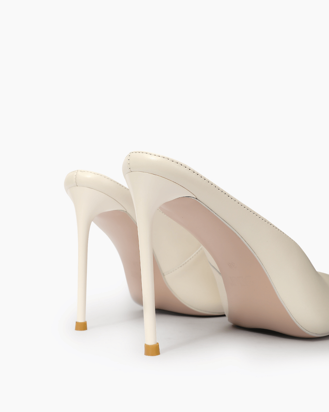 Ivory stiletto mule heel and gold-tone tip detail