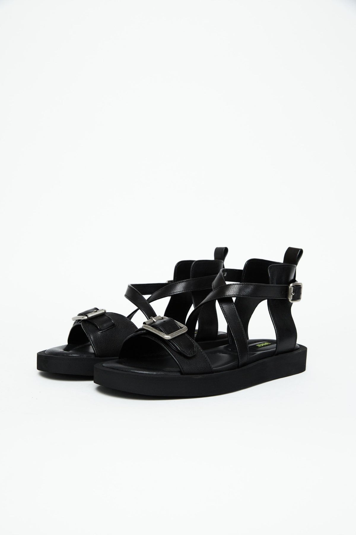 Pair of black leather platform sandals with front and ankle buckles, three-quarter view