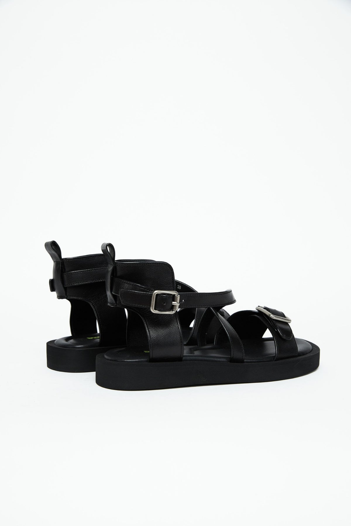 Rear side view of black leather harness sandals with structured heel panels