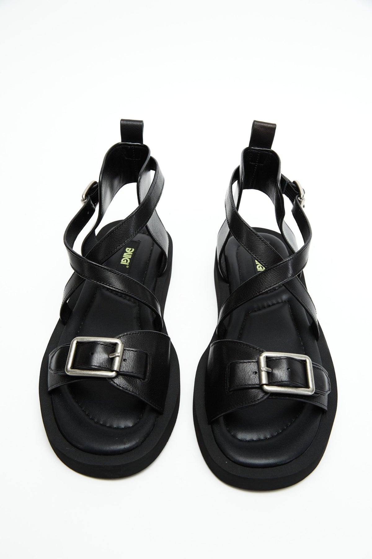 Top view of black genuine leather sandals with crossover straps and antique-silver buckles