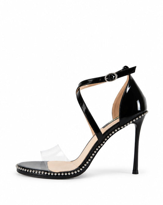 Black patent leather heels with clear toe strap and silver stud trim, side view