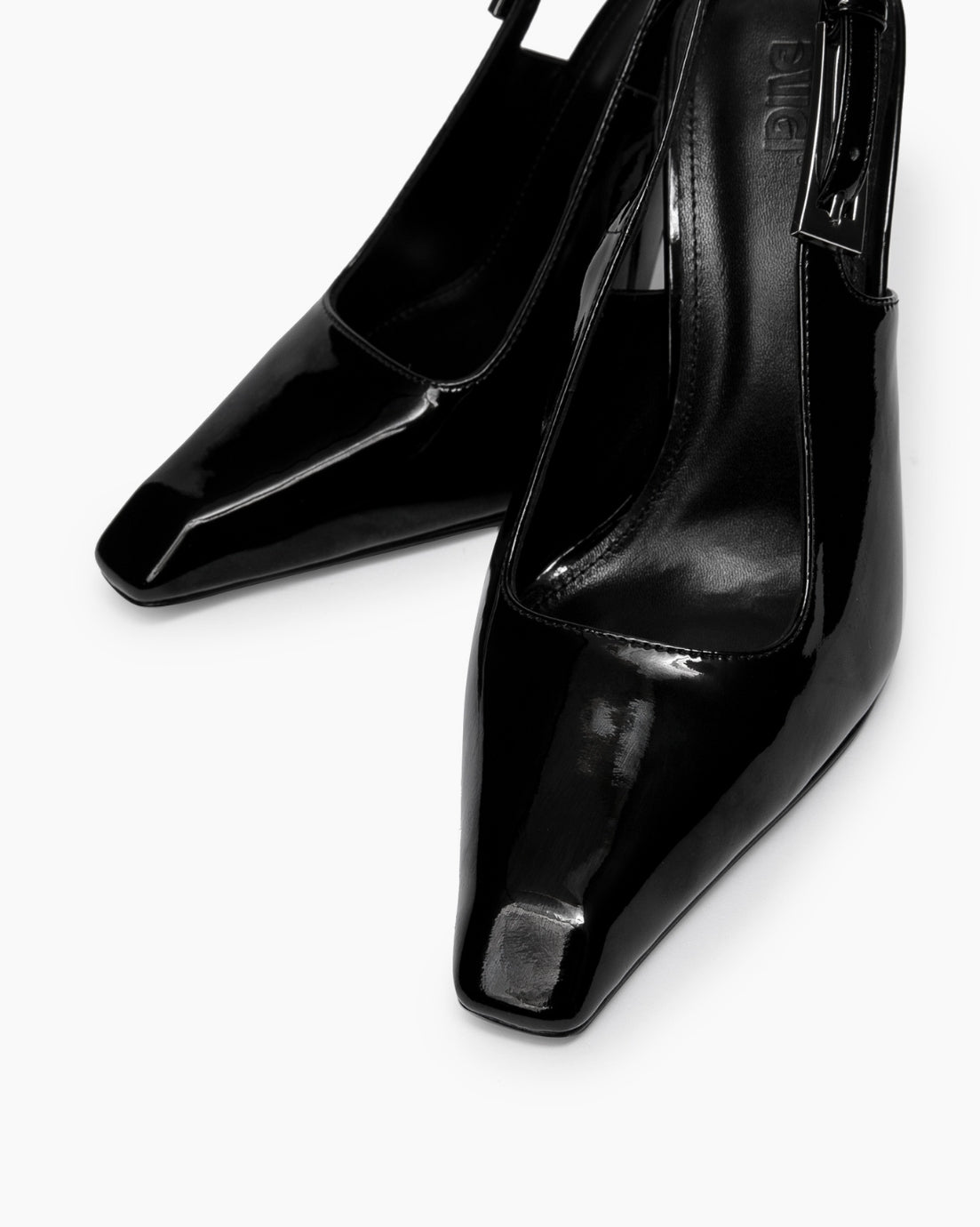 Close-up of glossy black patent slingback heels with elongated square toes