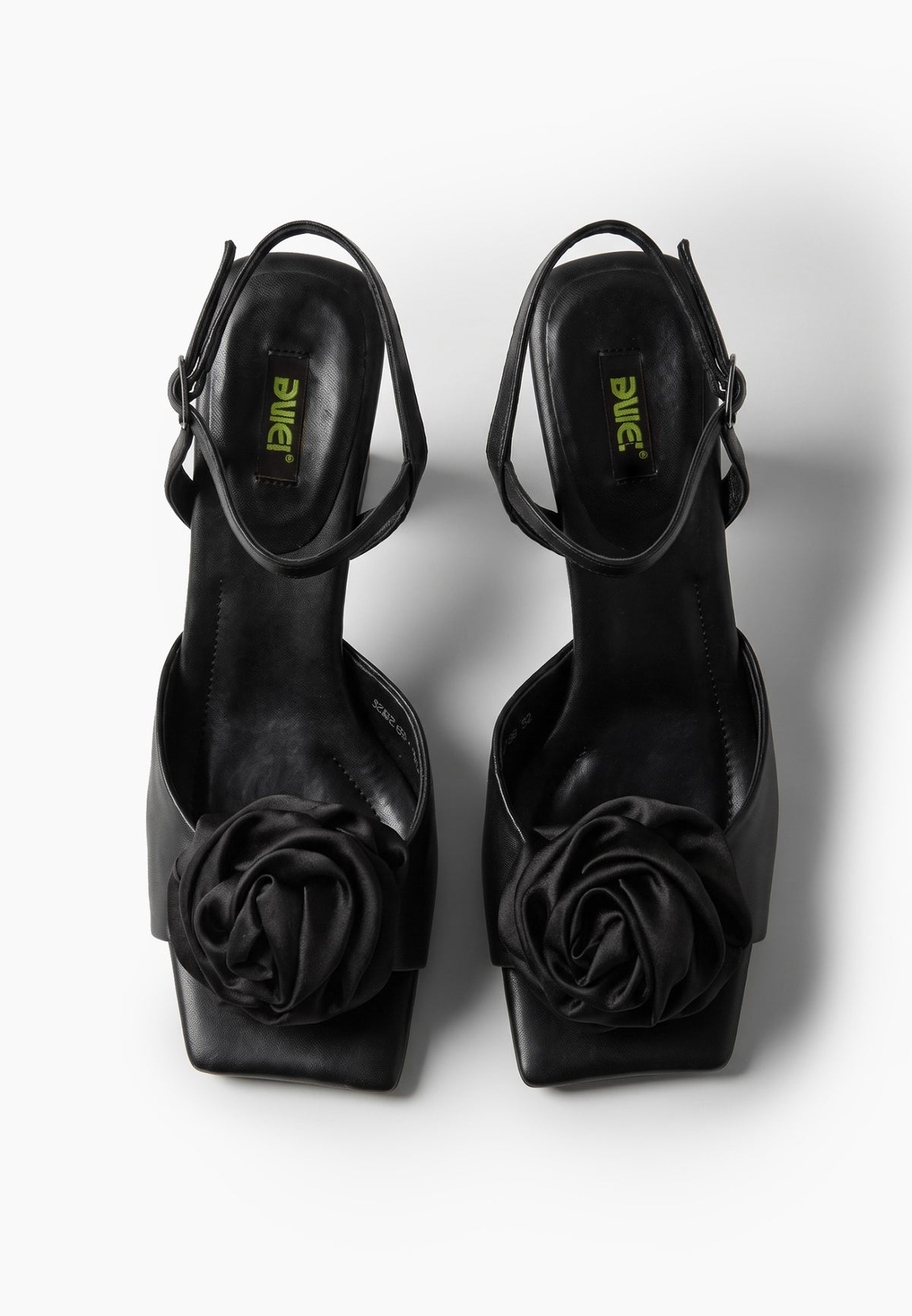 Black leather low-heel sandals with textile rosettes, top view