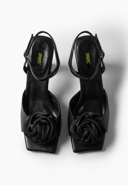 Black leather low-heel sandals with textile rosettes, top view