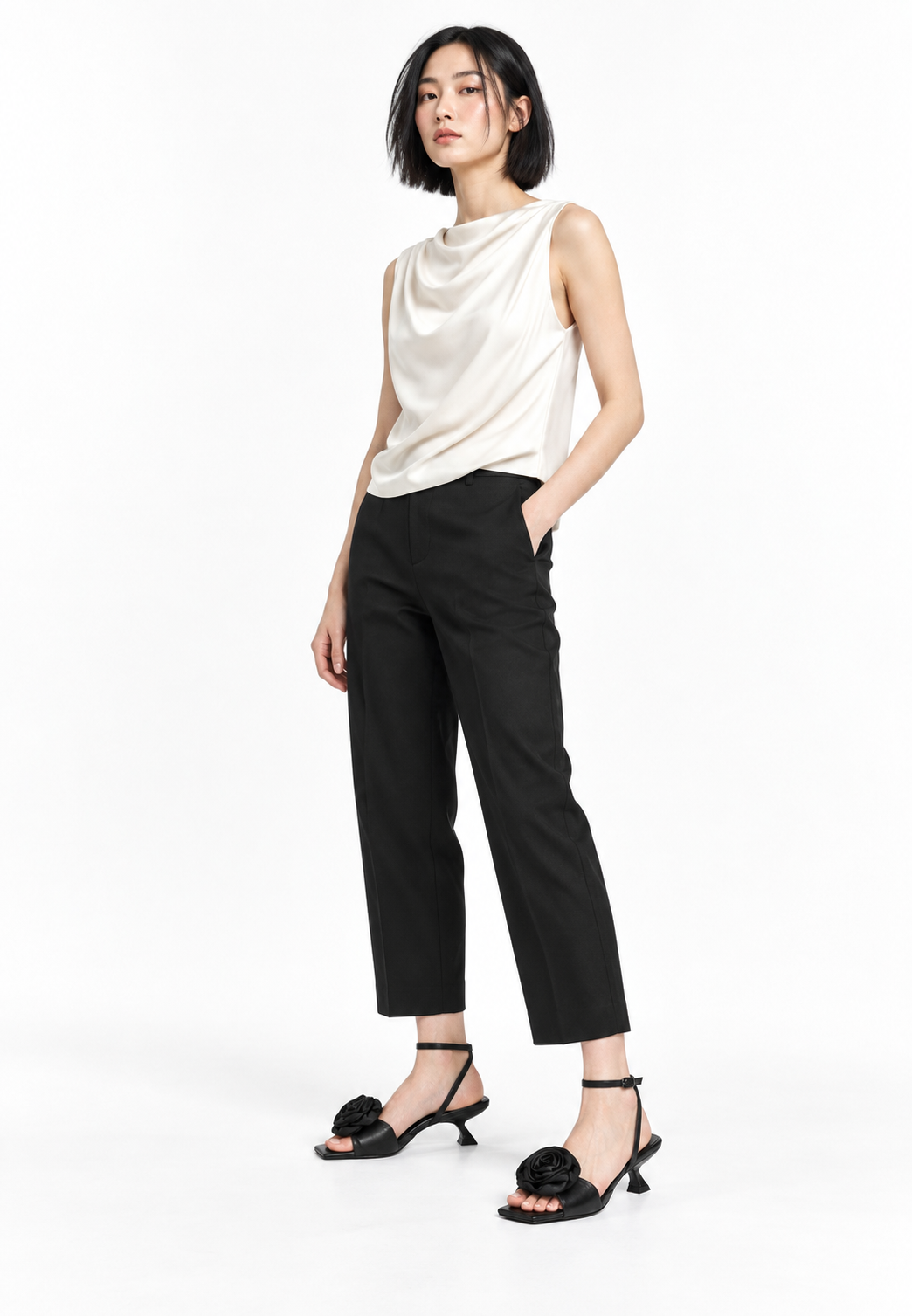 Black rosette sandals styled in a restrained white studio look