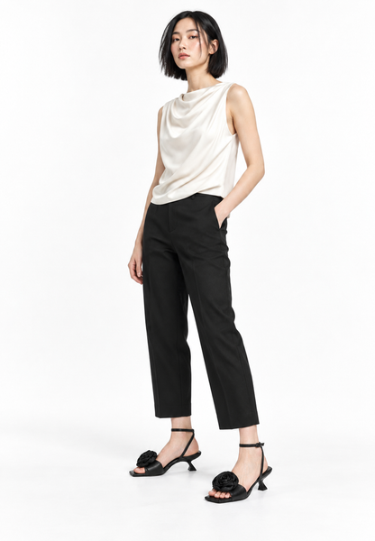 Black rosette sandals styled in a restrained white studio look