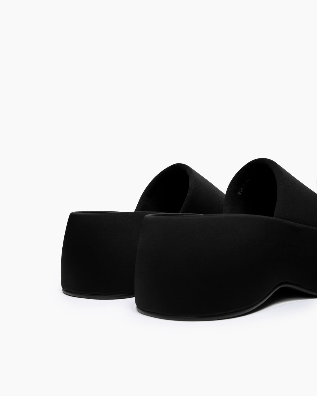 Rear view of black textile platform slides showing the sculpted sole profile