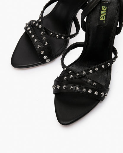 Close-up of black leather cross straps with round silver-tone studs and squared open toes