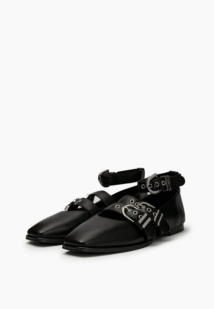 Pair of black leather ballet flats with square toes and silver-tone buckle straps