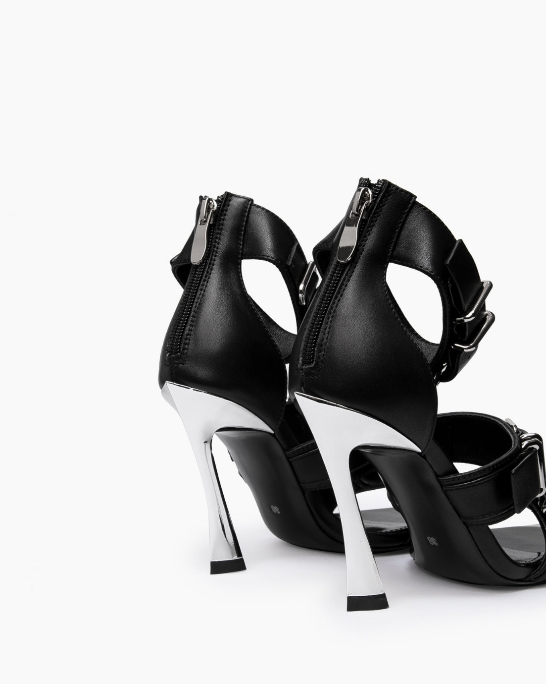 Rear view of black leather heels showing back zips and chrome-coated flared heels