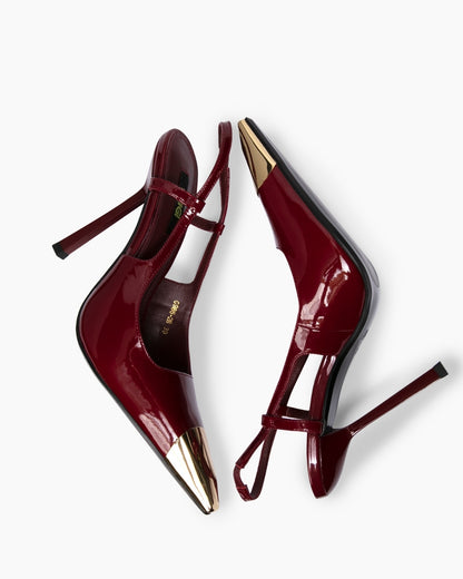 Top view of burgundy patent T-strap heels showing gold metal toes and slim stilettos