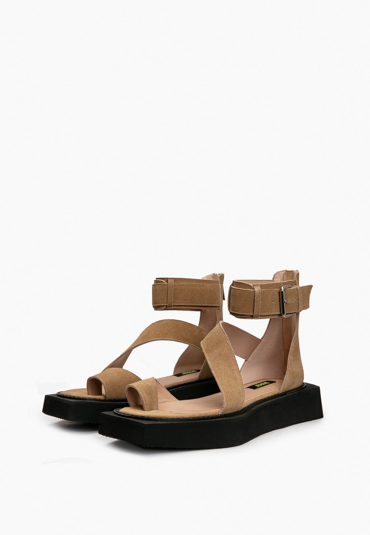 Pair of camel suede buckle sandals with asymmetric straps and black platform soles