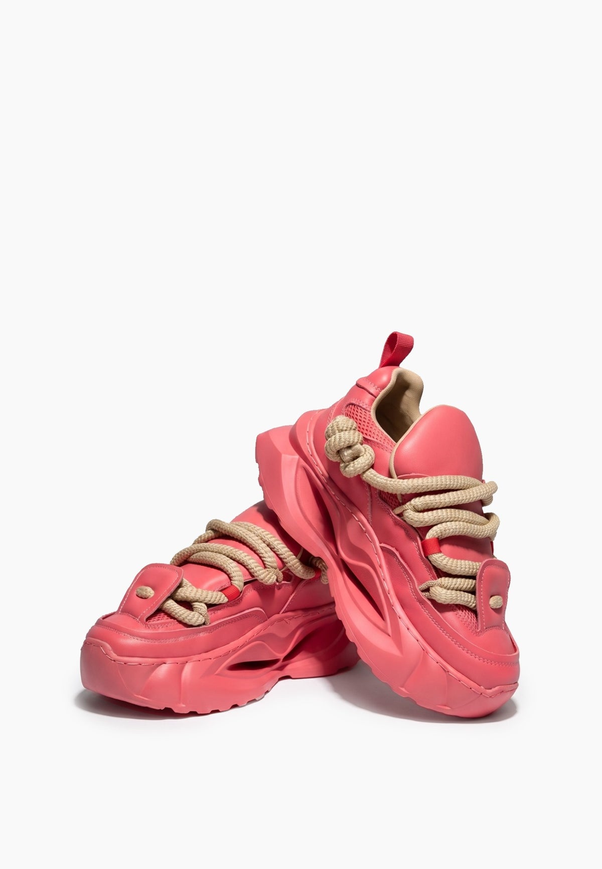Pair of coral pink chunky sneakers showing rope laces and sculpted soles