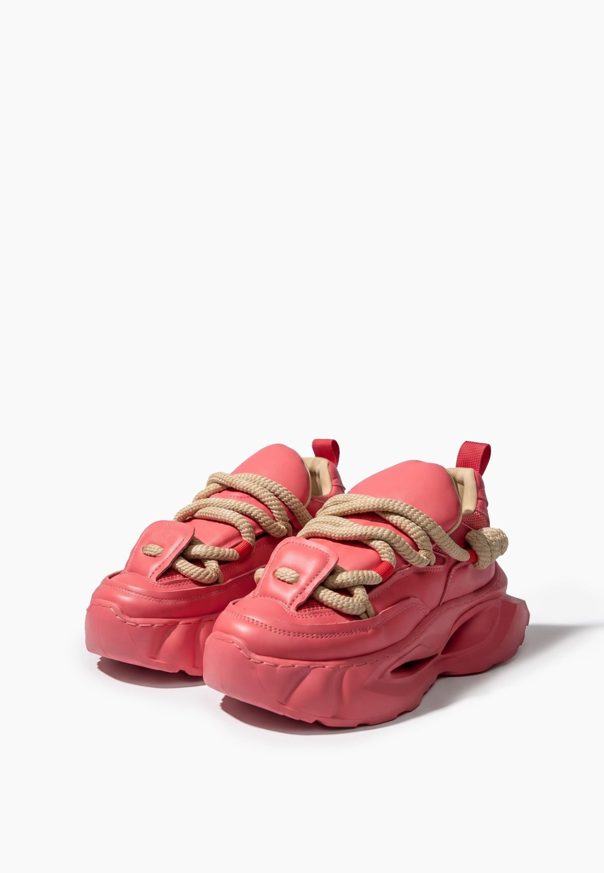 Front three-quarter view of coral pink rope-lace platform sneakers