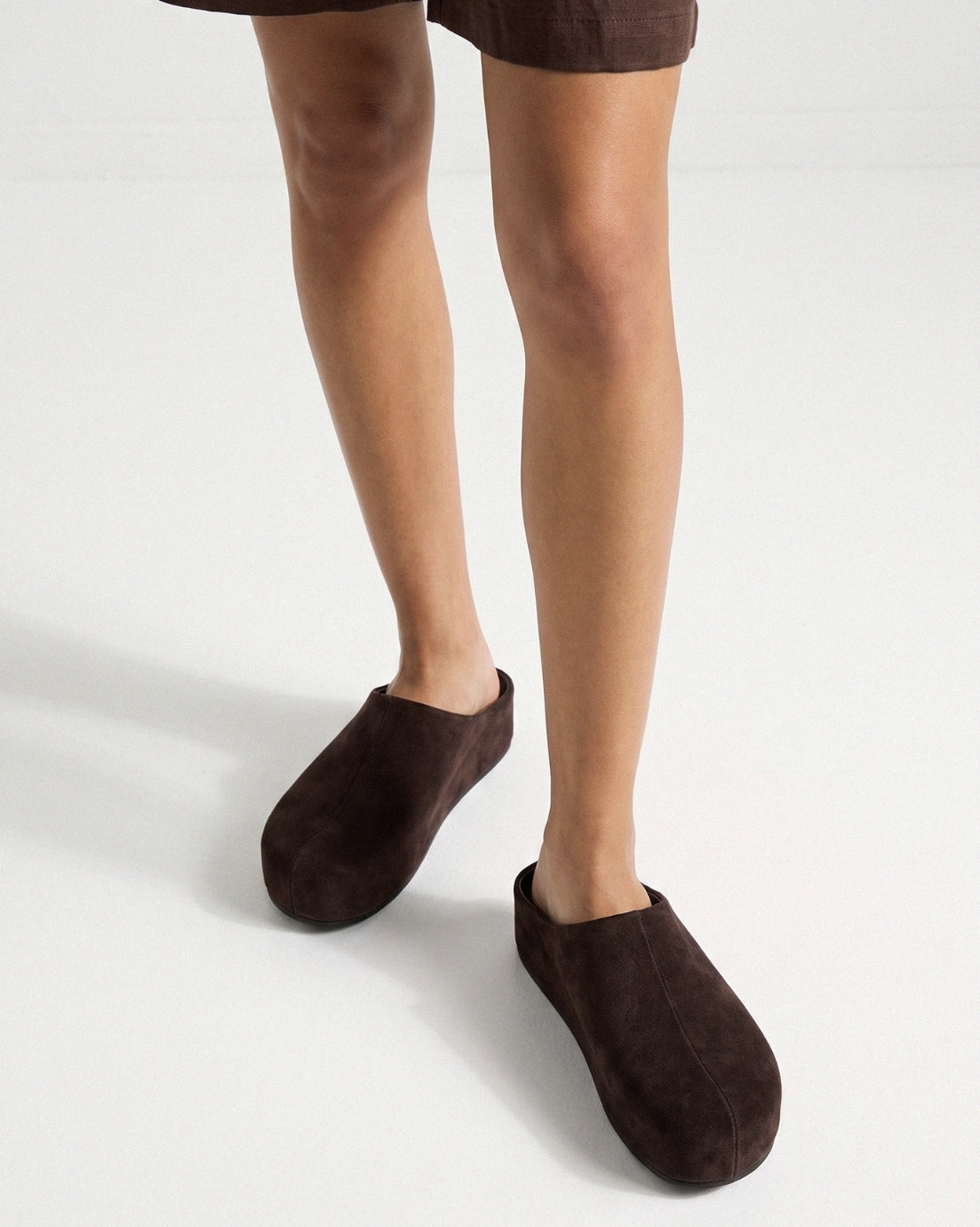 Dark chocolate suede slip-on clogs worn in studio