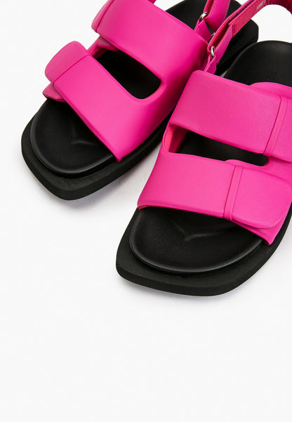 Close-up of fuchsia pink padded leather straps and cushioned black footbed