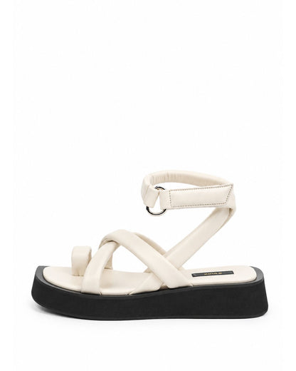 Ivory leather toe-loop flatform sandal with padded crossover straps and black sole, side view