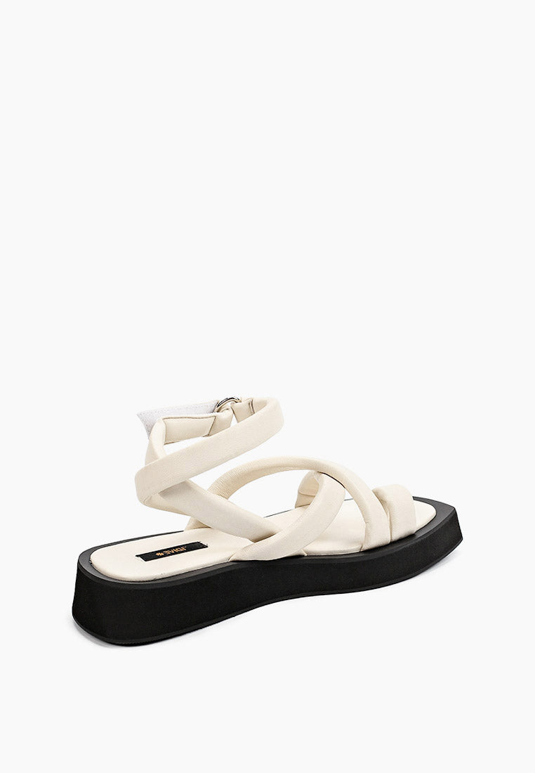 Rear three-quarter view of ivory crossover sandals with wrapped ankle strap
