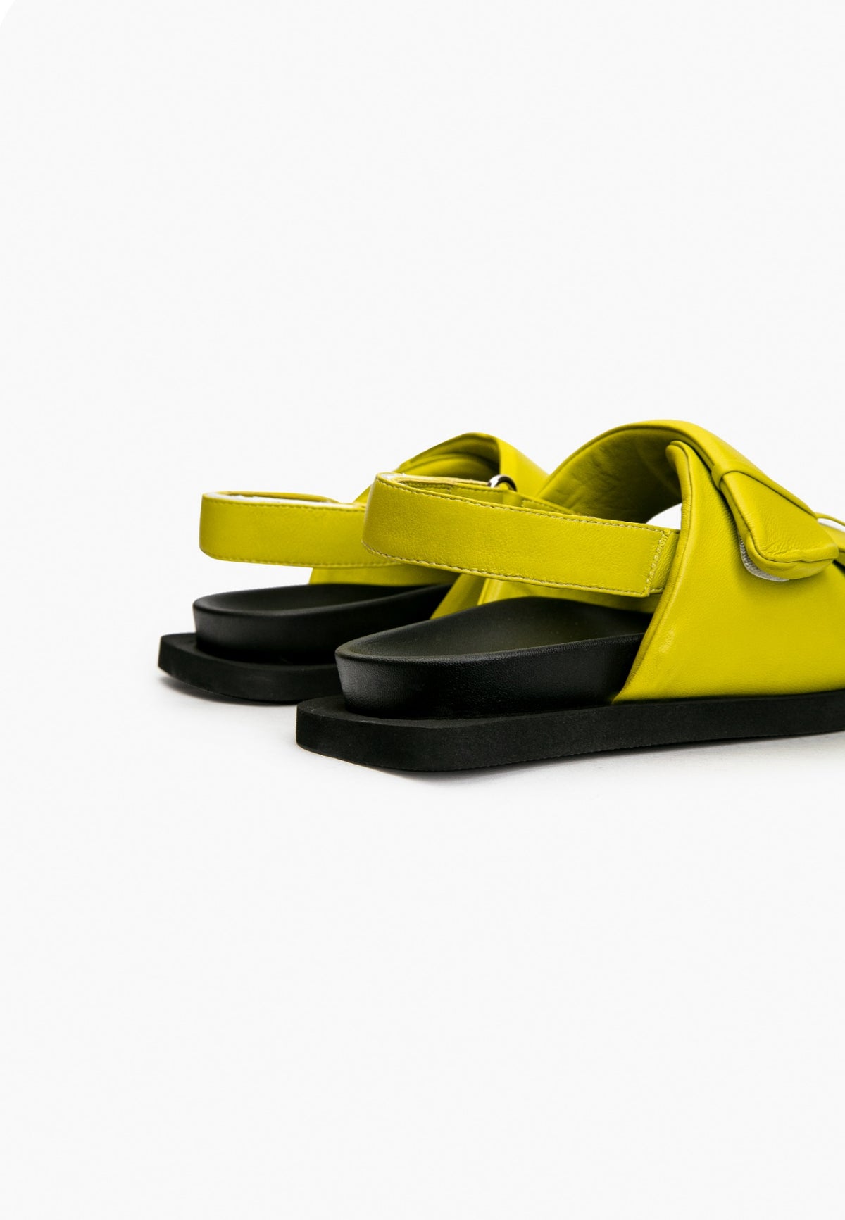 Rear view of lime green leather sandals with adjustable heel straps