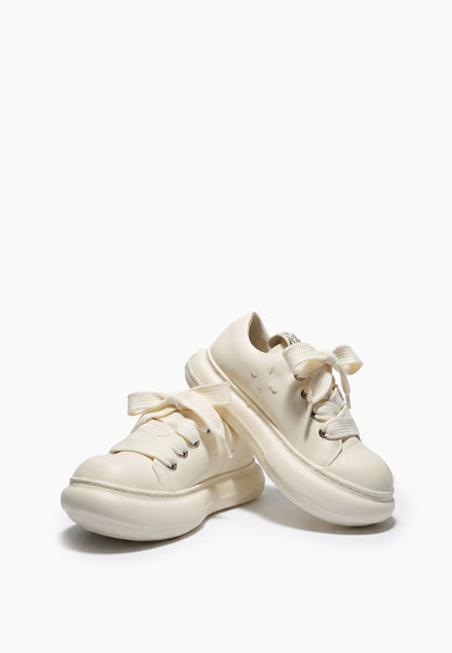 Pair of milky ivory leather sneakers with wide laces and chunky soles