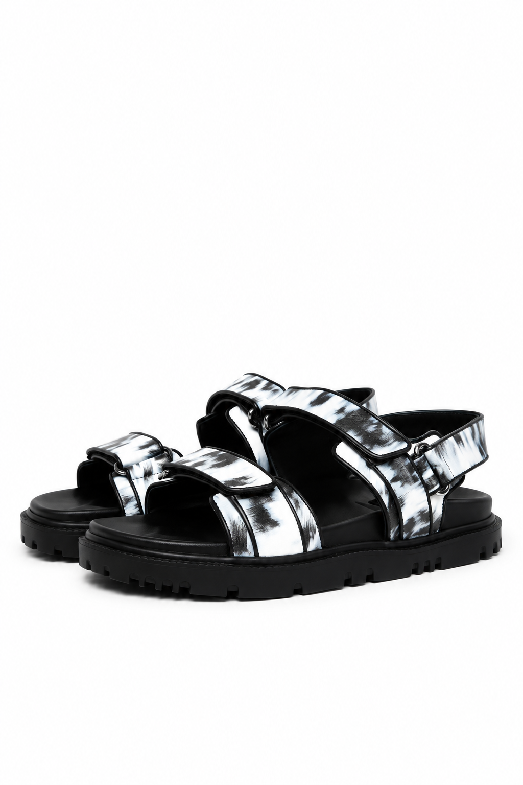 Pair of monochrome printed leather sandals with black lug soles, three-quarter view