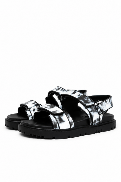 Pair of monochrome printed leather sandals with black lug soles, three-quarter view
