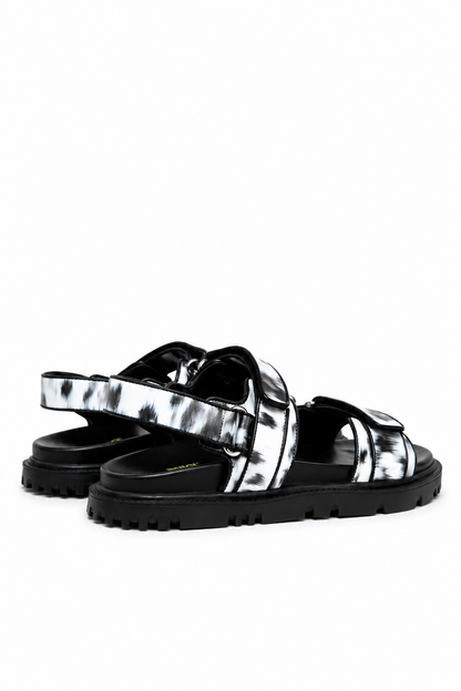 Rear side view of printed leather sandals with ankle strap and black treaded sole