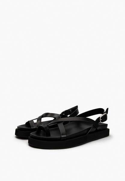 Pair of black leather toe-loop sandals with slim crossover straps