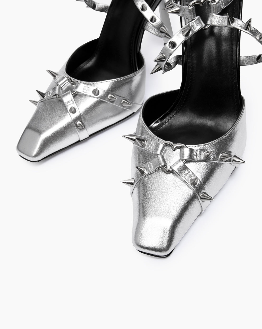 Close-up of silver leather square toes, heart-shaped rings and spike details