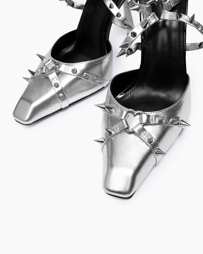 Close-up of silver leather square toes, heart-shaped rings and spike details