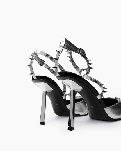 Rear close-up of reflective angular heels and silver spiked ankle straps