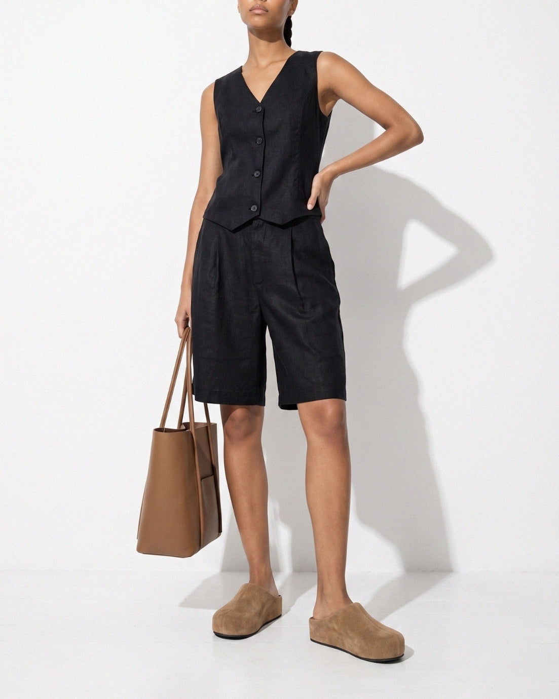 Taupe suede slip-on clogs styled in a monochrome studio look